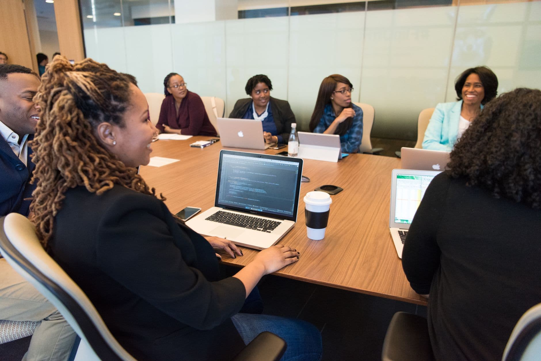 Coworkers gathered around laptops in an office