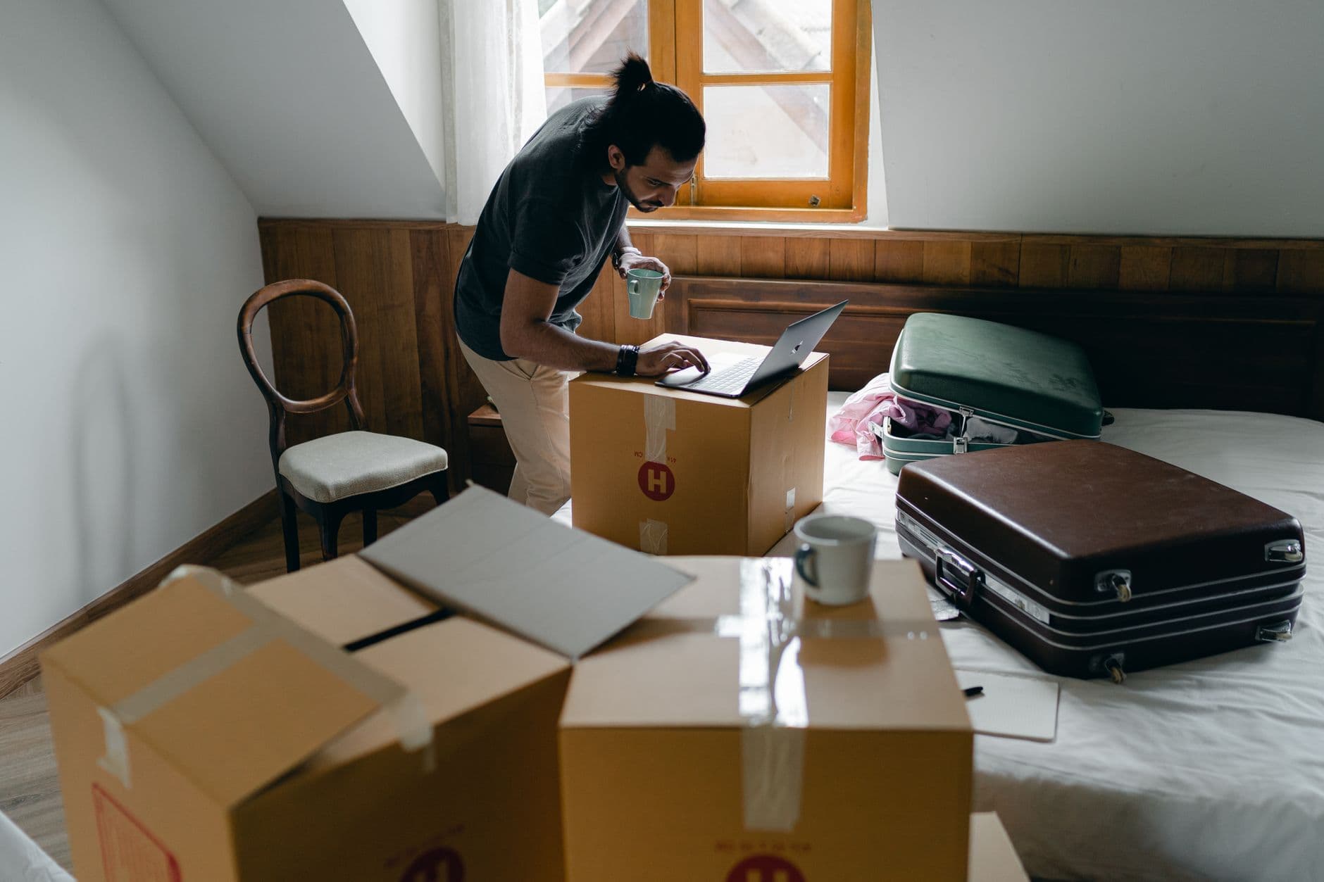 Packing boxes beside a laptop, standing in for a free move to a new host