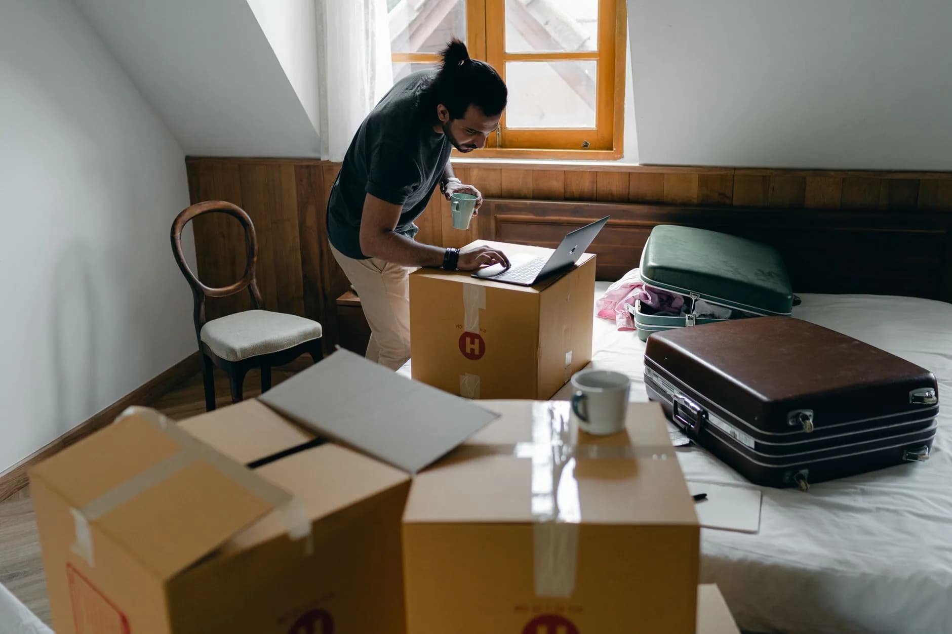 Packing boxes beside a laptop, standing in for a free move to a new host
